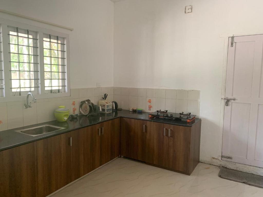 a kitchen with a sink and a counter top at Casa Ganesha beach residence in Irimbranallūr