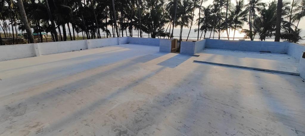 an unfinished roof of a house with trees in the background at Casa Ganesha beach residence in Irimbranallūr