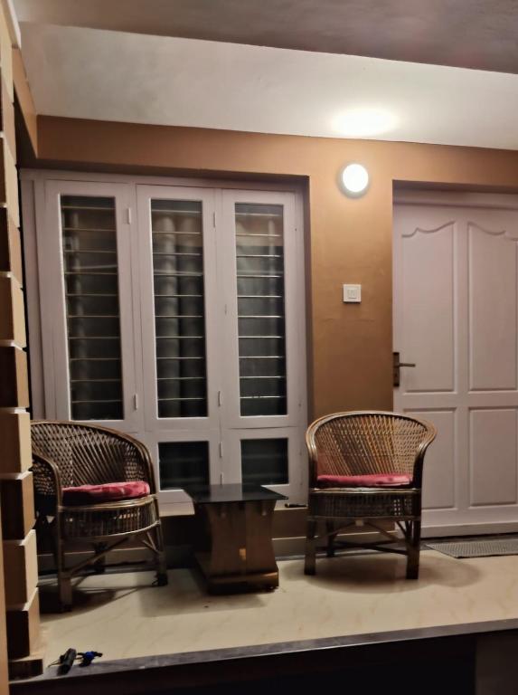 a living room with two chairs and a table at Casa Ganesha beach residence in Irimbranallūr