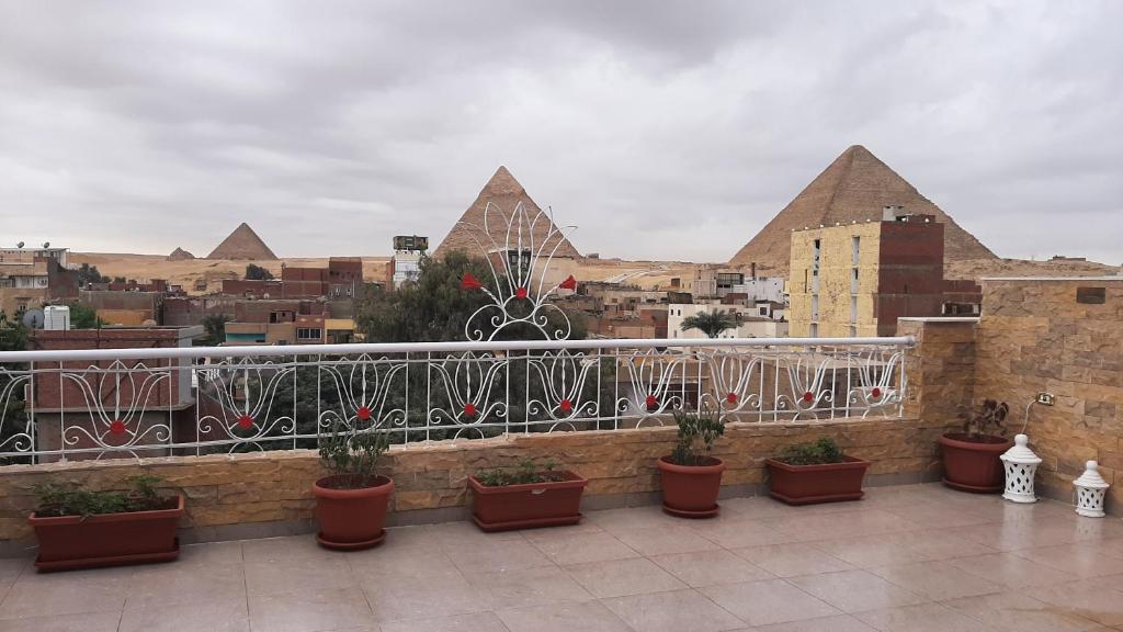 a balcony with potted plants and buildings in the background at Gohar Guest House in Cairo