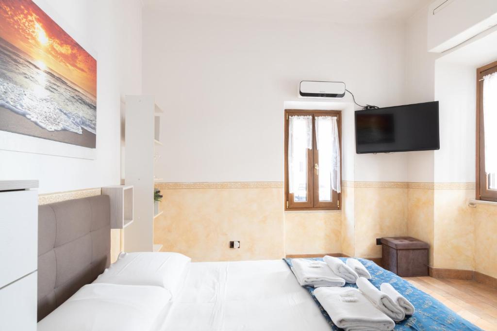 罗马Elegant & Quiet Apartment next to Colosseo的卧室里有一张白色的床和一台平板电视