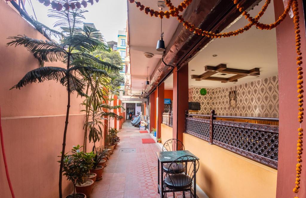 een gang van een gebouw met stoelen en planten bij Traveler's Holiday Inn in Kathmandu