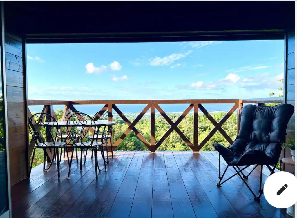 今歸仁的住宿－ハルク キャビン，阳台配有椅子,享有海景。
