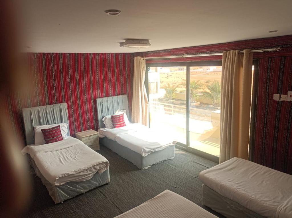 a hotel room with two beds and a large window at alsaif camp in Bidiyah
