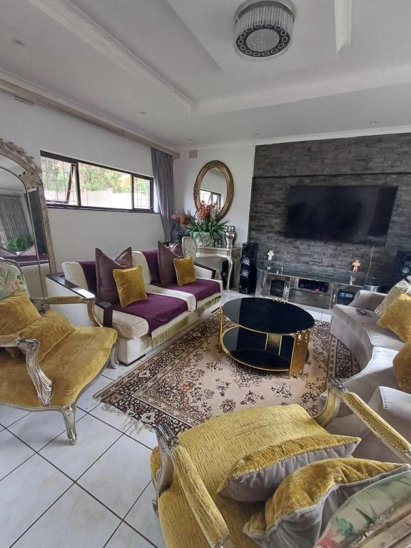 una gran sala de estar con sofás y chimenea. en Margate Accomodation en Margate