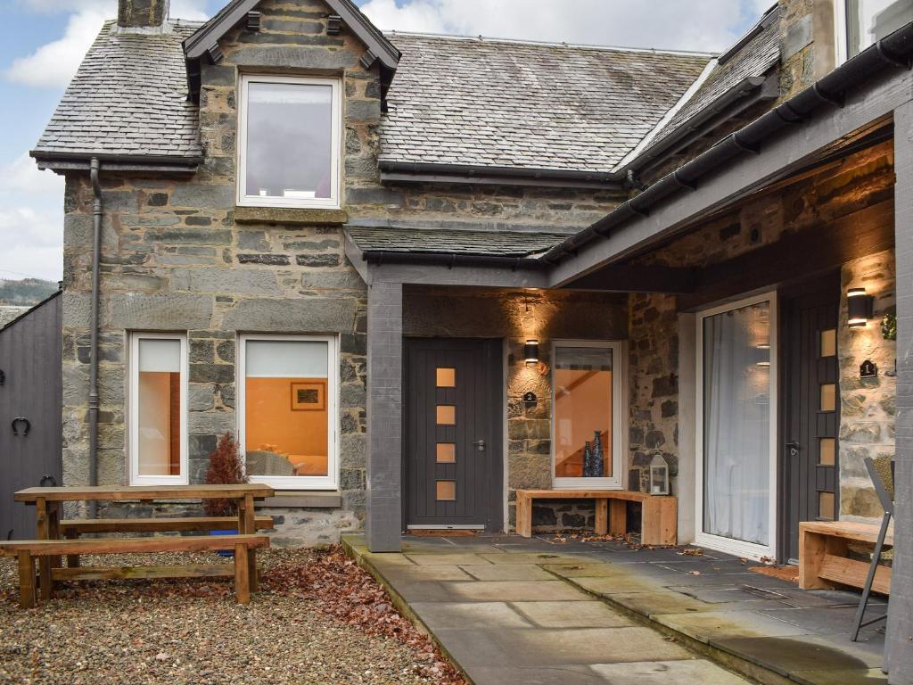 a stone house with a bench outside of it at Cottage No,2 - Uk41847 in Aberfeldy