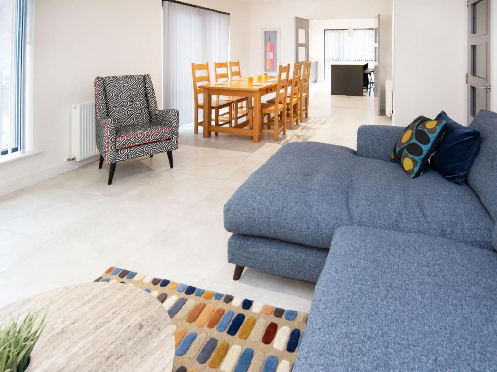 a living room with a blue couch and a table at Caledonia View in Aviemore