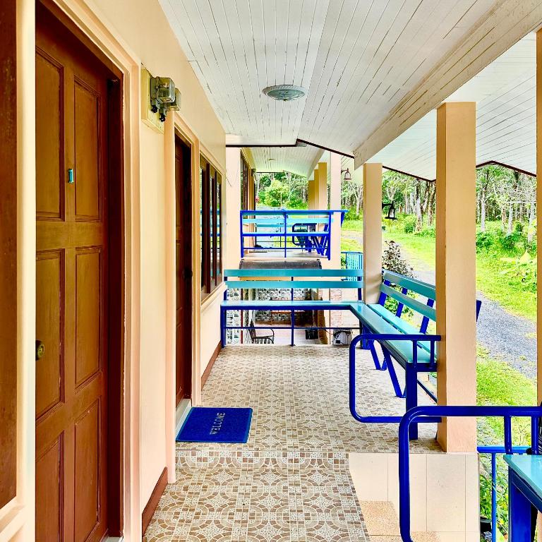 a porch with blue benches on a house at Chamil House (ชามิล เฮ้าส์) 