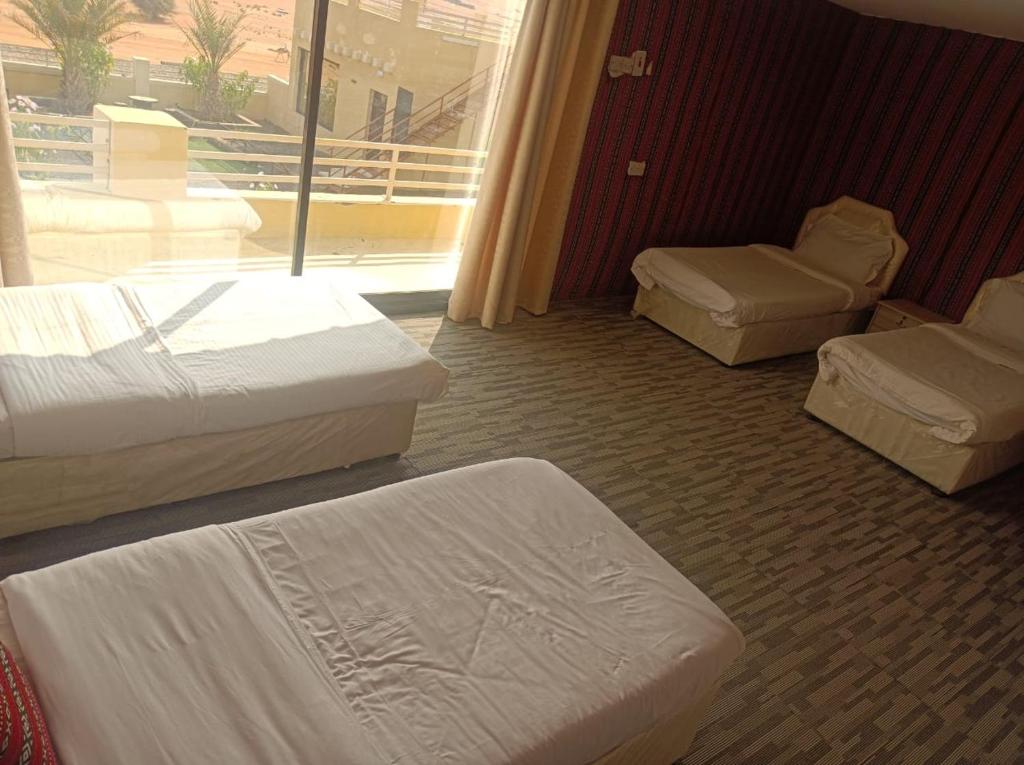 a hotel room with three beds and a window at alsaif camp in Bidiyah