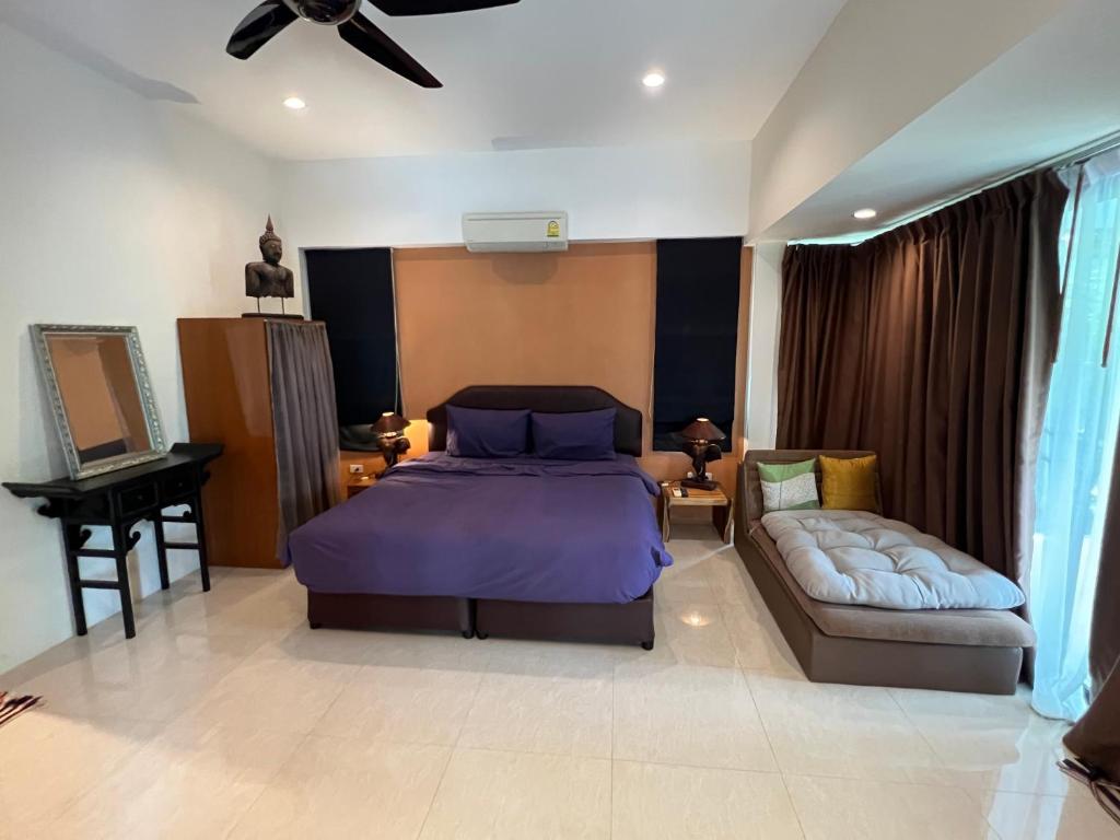 um quarto com uma cama roxa e um sofá em Villa Roland em Lamai