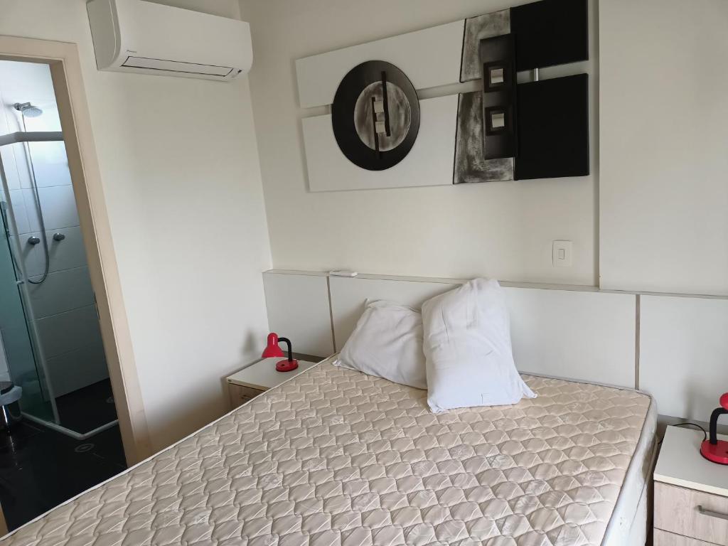 una camera con un letto con due cuscini sopra di Riviera de São Lourenço - Porto de Galles a Bertioga