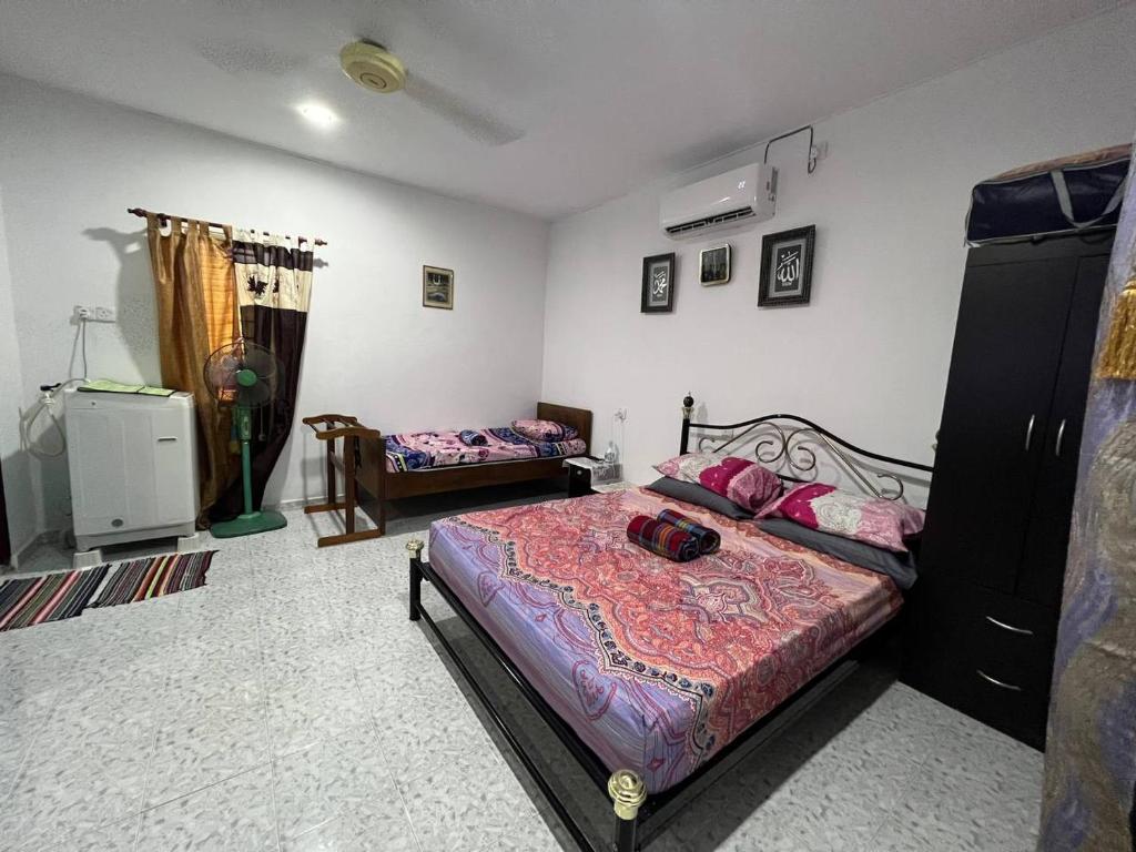 Nipah Medium Roomstay Parit Buntar في باريت بونتار: غرفة نوم مع سرير وأريكة وسرير سيد