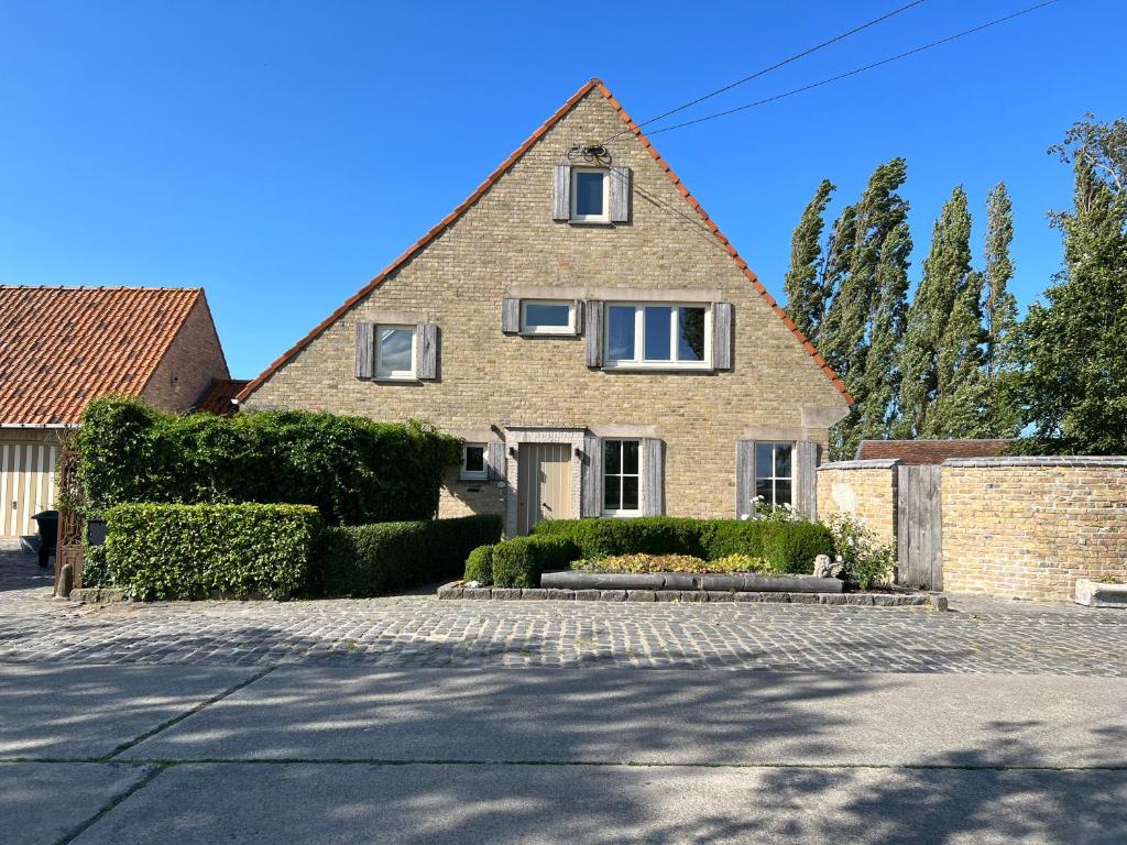 een groot bakstenen huis met een dak bij De Landsgenieter in Nieuwpoort