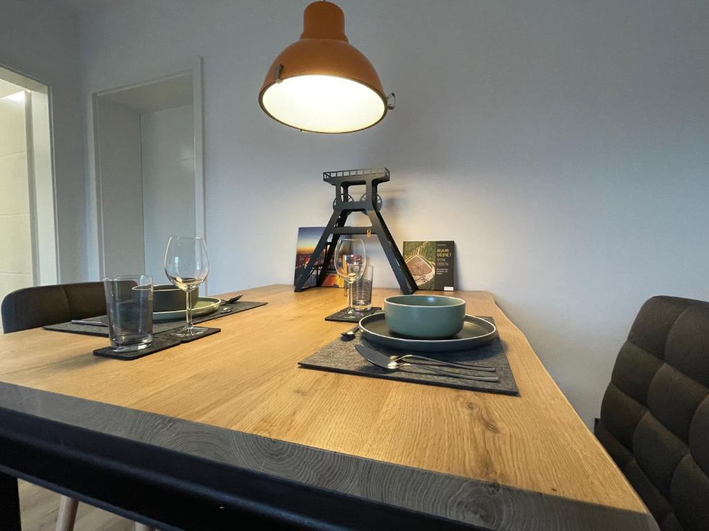een houten tafel met een bord eten en een lamp bij Zechenbude - Erlebe das Ruhrgebiet in Gladbeck