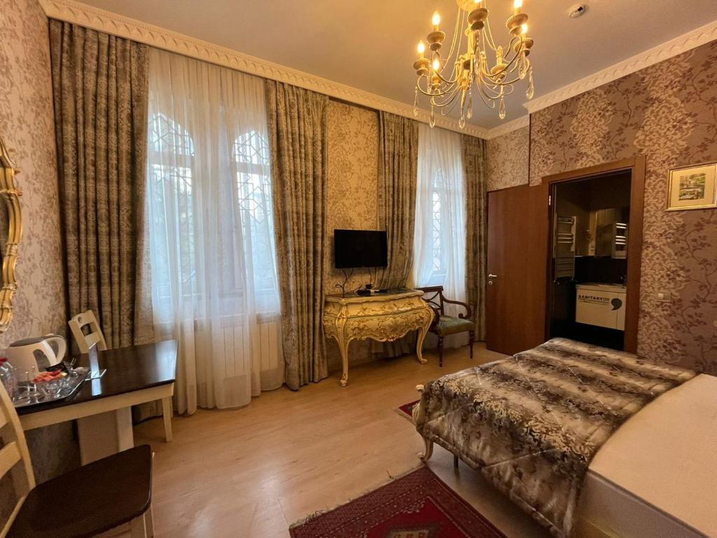 a bedroom with a bed and a desk and a television at La Casa Old City Hotel in Baku