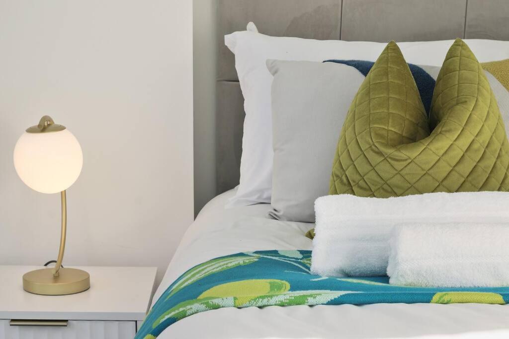 - un lit avec des oreillers blancs et une lampe sur une table dans l'établissement 4 Bed House Near Trent Bridge, à Nottingham
