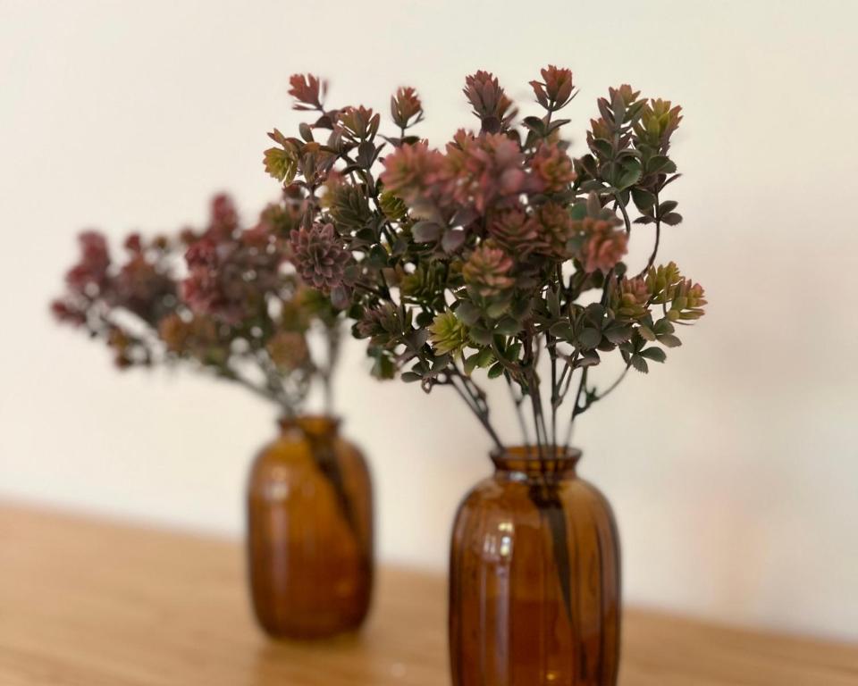 two brown vases with flowers in them on a table at Gemütliche Wohnung Nähe Uni in Basel