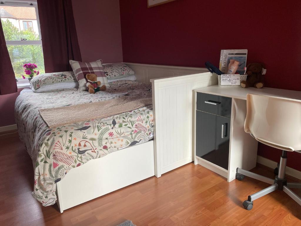 a small bedroom with a bed and a desk at Country home near the airport in Edinburgh
