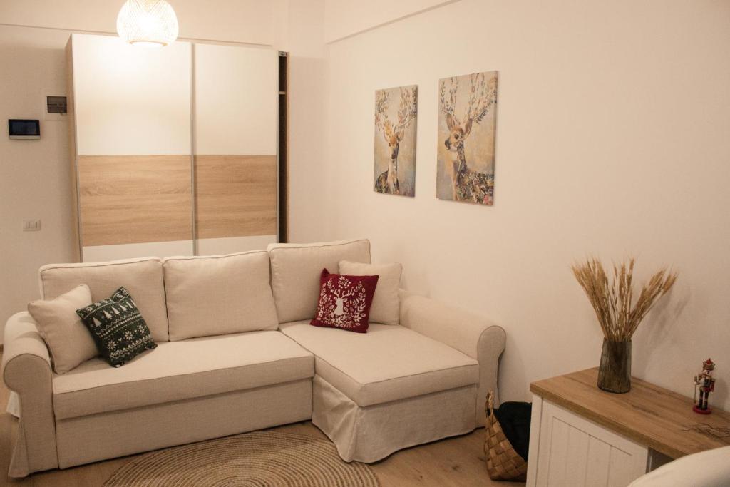 a living room with a couch and paintings on the wall at Scandinavian for you in Bacău