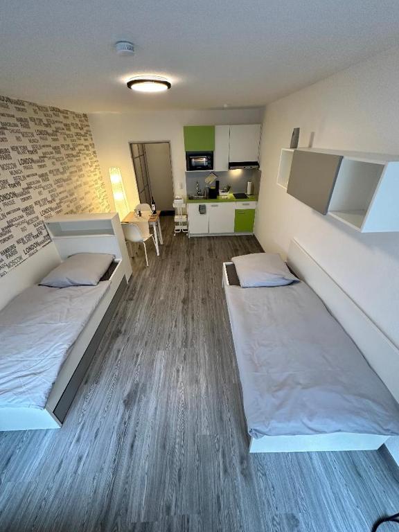 Habitación con 2 camas y cocina. en Apartment Kompakt 24/7, en Kassel