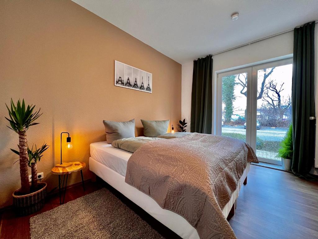 a bedroom with a large bed and a large window at Aura - Nula #1 -2 Zimmer, 4 Betten, Küche, Balkon, Waschmaschine in Merseburg