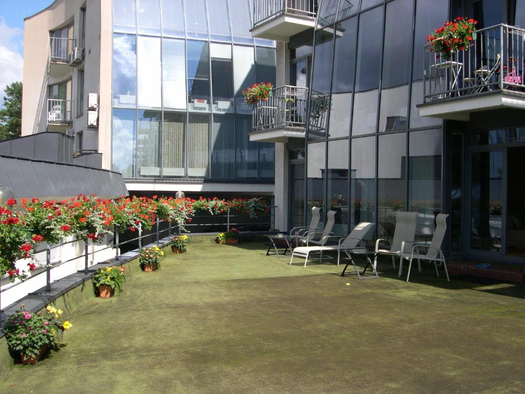 帕蘭加的住宿－維拉維奧拉公寓，一座带椅子和鲜花的建筑的庭院