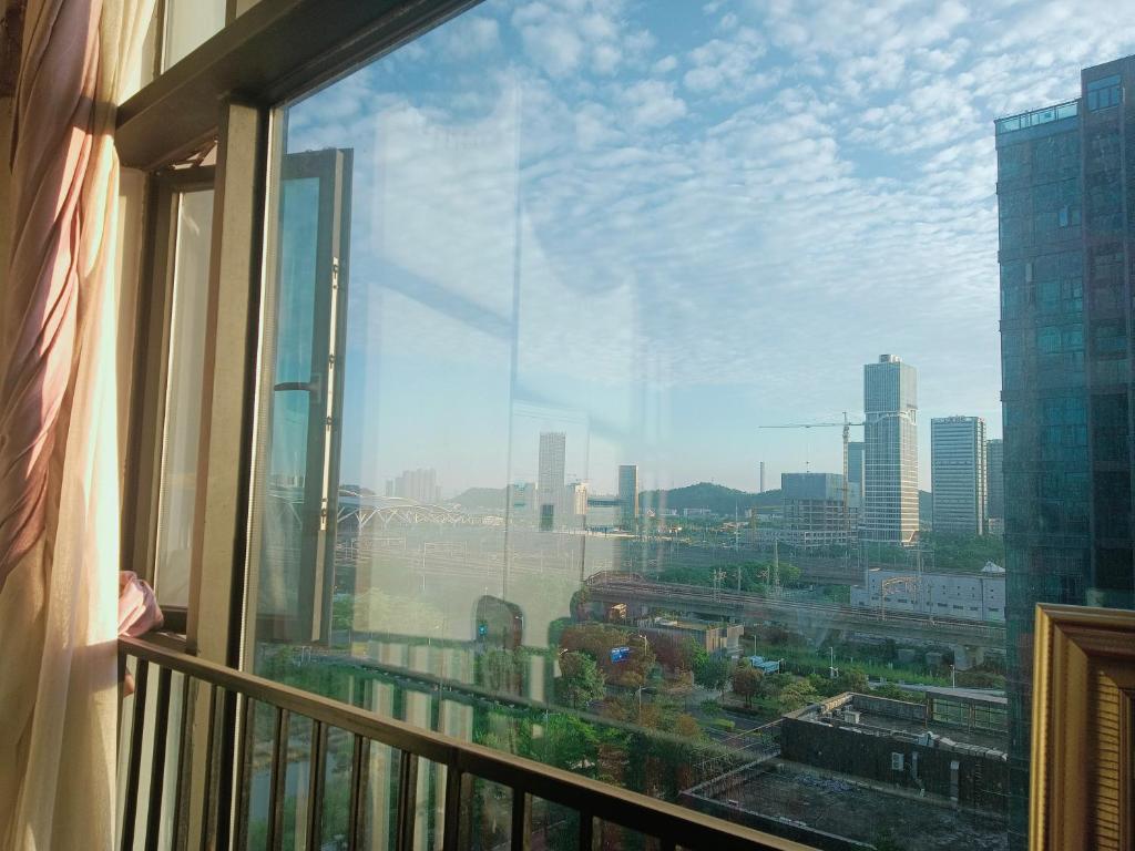 uitzicht op de stad vanuit een raam van een gebouw bij Meiju Apartment in Guangzhou