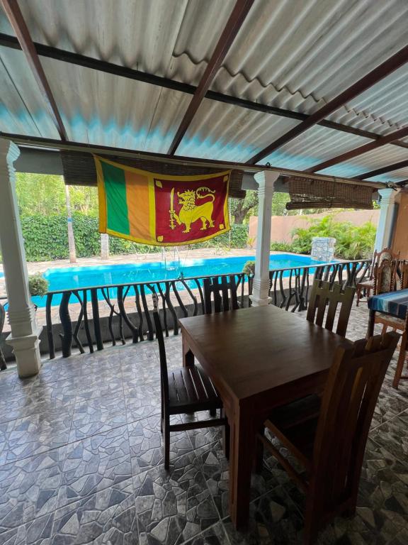 une table avec des chaises et un drapeau sur celle-ci dans l'établissement TEMBO Cottage Wilpattu, à Wilpattu