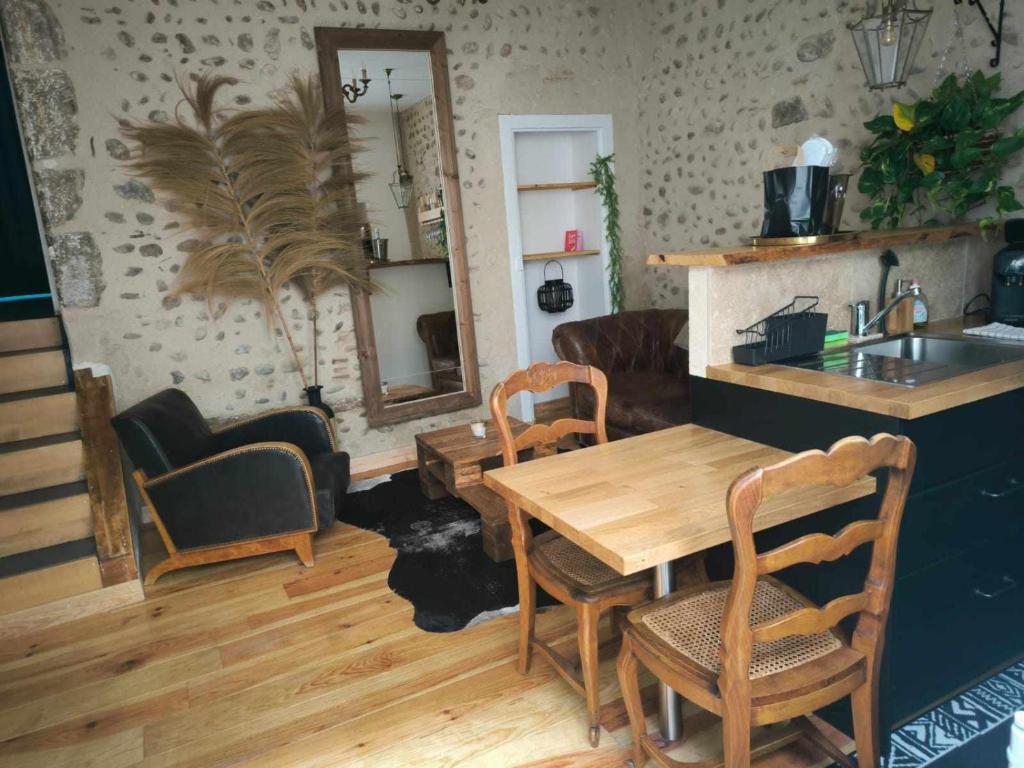 sala de estar con mesa de madera y sillas en L'antre d'Eros, en Romans-sur-Isère
