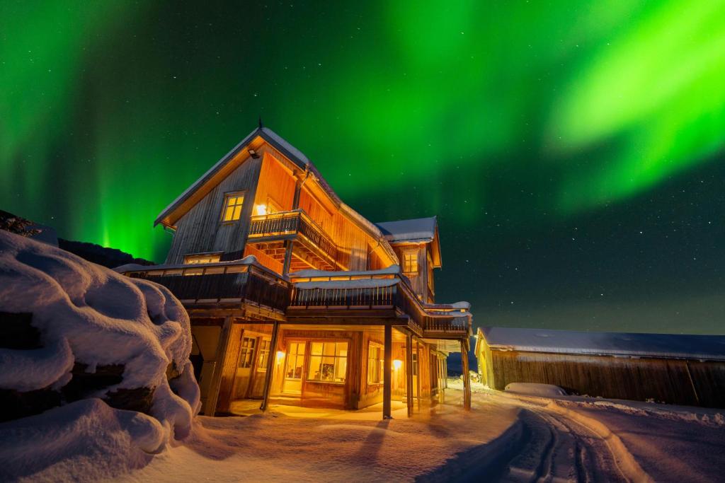 a house with the aurora in the sky at Villa Nestun - secluded oasis near Tromsø city in Selnes