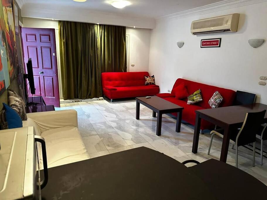 a living room with a red couch and a table at One - bedroom building 174 in Sharm El Sheikh