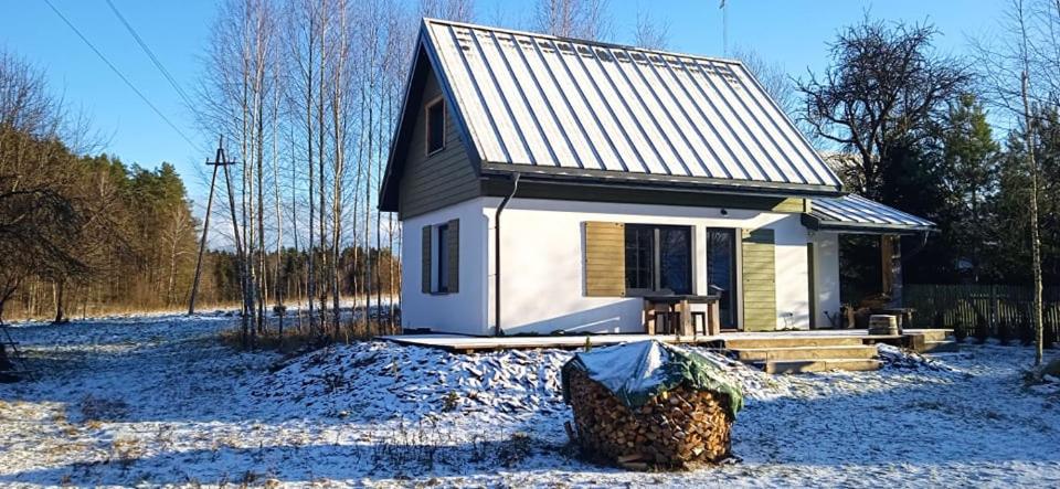 una pequeña casa en un campo con nieve en Na Skraju Szlaków, en Sernetki