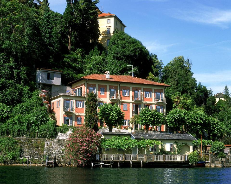 een gebouw aan de kant van een heuvel naast het water bij Lake view rooms and flats Casa Sul Lago in Orta San Giulio