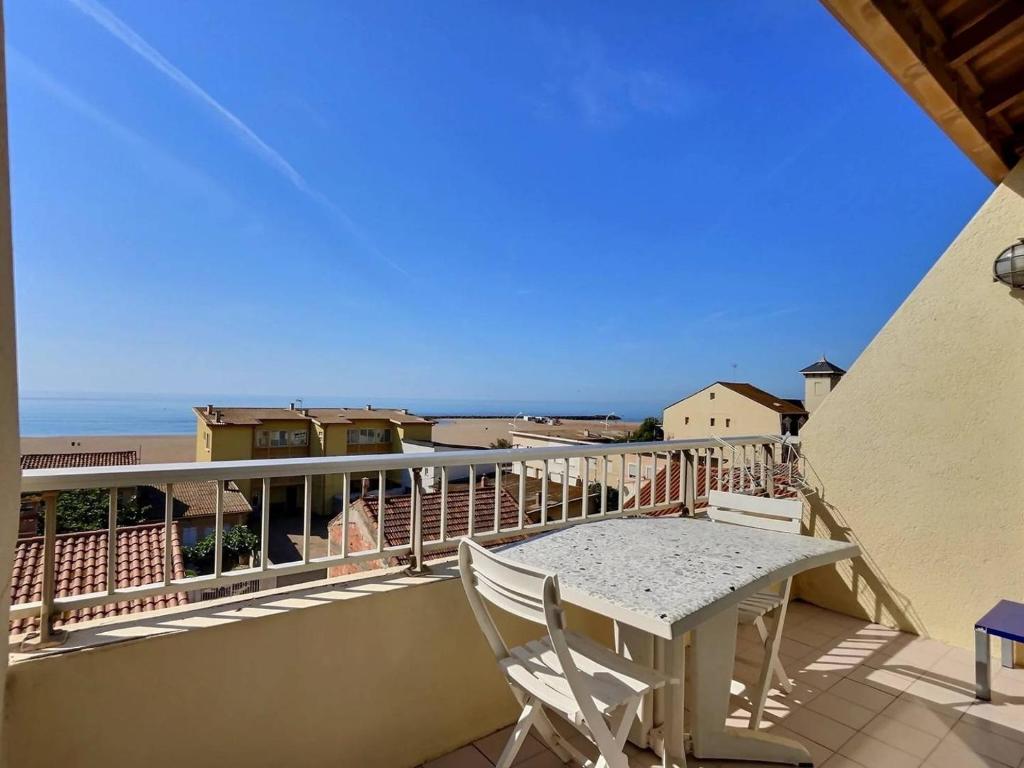 a balcony with a table and a view of the ocean at Appartement vue mer en plein centre de Valras-Plage in Valras-Plage