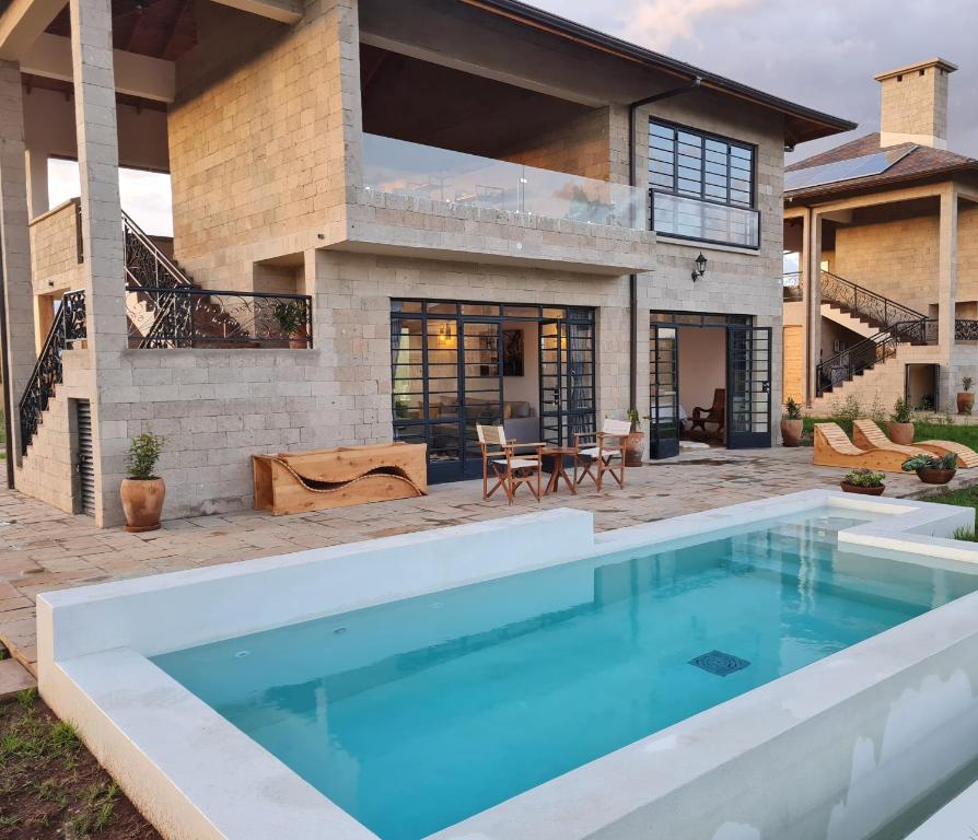 a pool in the backyard of a home with a house at The Landing Nanyuki Cottages in Nanyuki