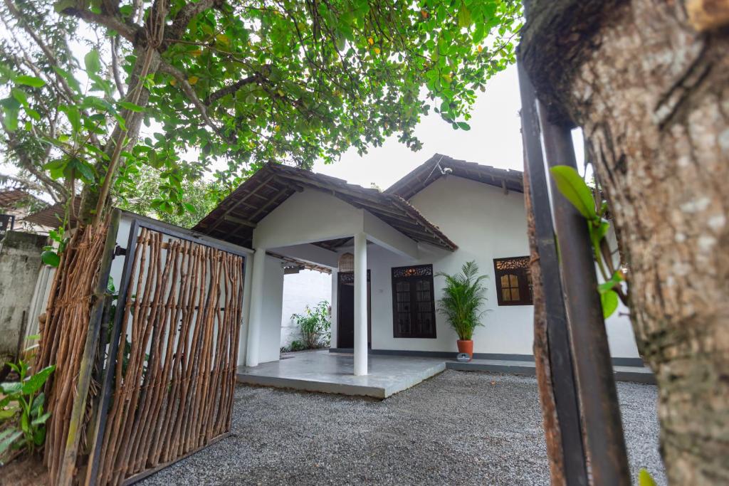 a house with a gate in front of it at Coconut Cottage - Hiriketiya Beach in Hiriketiya