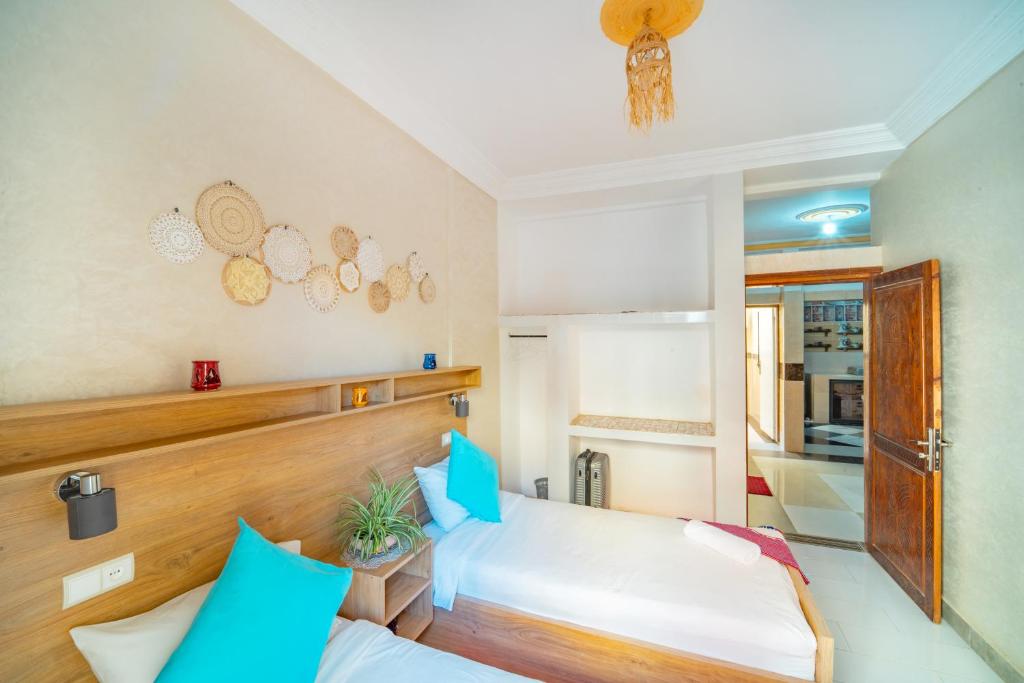 - une chambre avec 2 lits dotés d'oreillers bleus dans l'établissement Appartements partagé à 10 min devil's rock surf spot, à Aourir