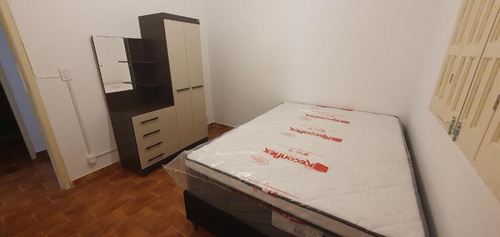 a bed in a room with a dresser and a bedvertisement at Casa Temporada Guriri Céu Azul in Guriri