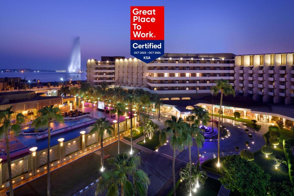 una città di notte con un cartello che dice un ottimo prezzo per lavorare di InterContinental Jeddah, an IHG Hotel a Gedda