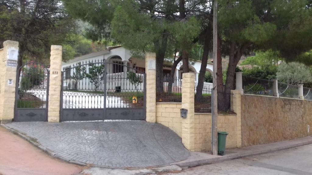 une clôture blanche avec un portail en face d'une maison dans l'établissement Villa Lucía, à Alhaurín de la Torre