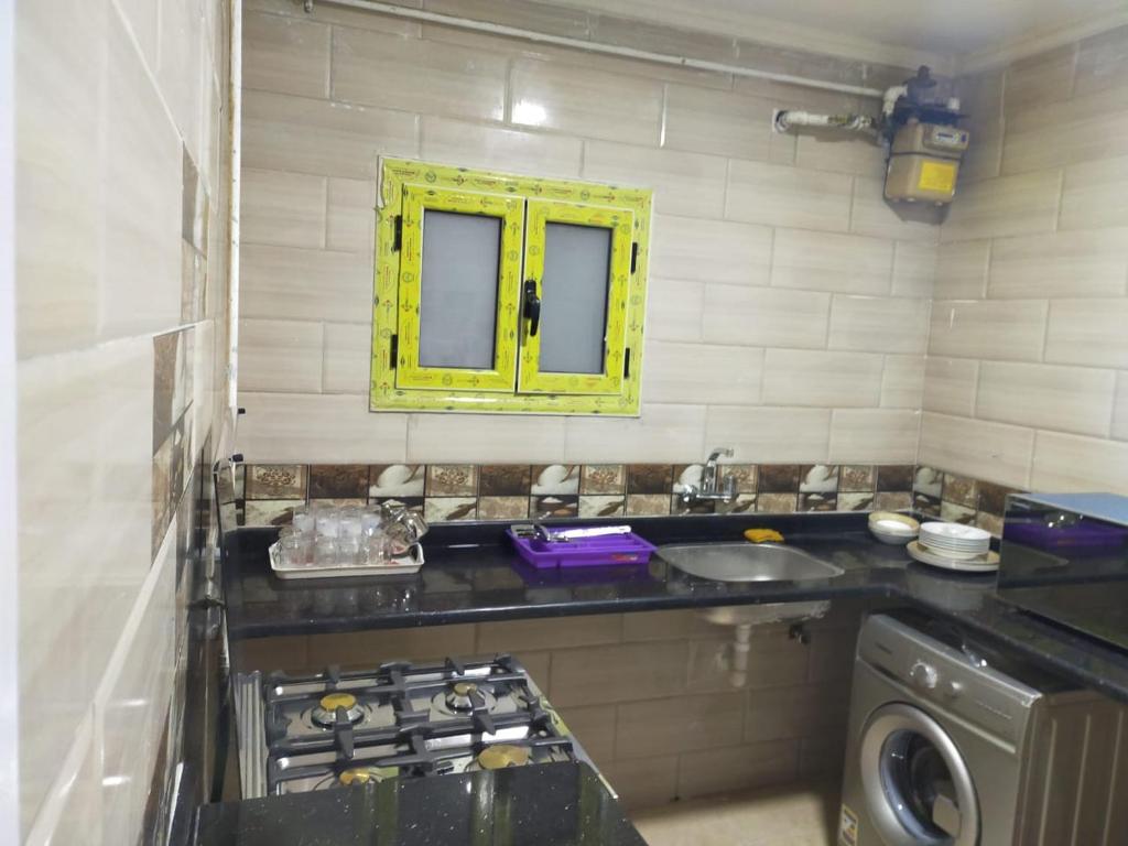 a kitchen with a sink and a washing machine at سيتى سكوير سيدى جابر عالبحر in Alexandria