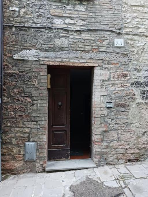 - une porte dans un bâtiment en pierre avec une porte de service dans l'établissement Casa vacanza Raffaela, à Gubbio