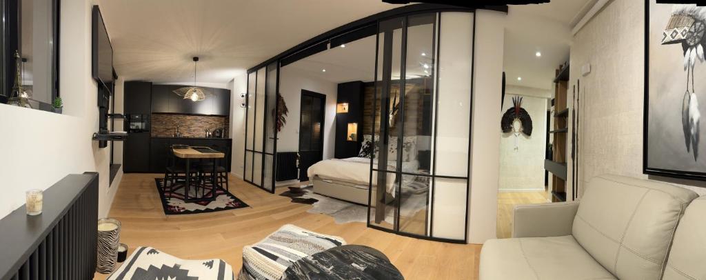 a living room with a white couch and a bedroom at Appartement vue Tour Eiffel paris 16 Eme in Paris