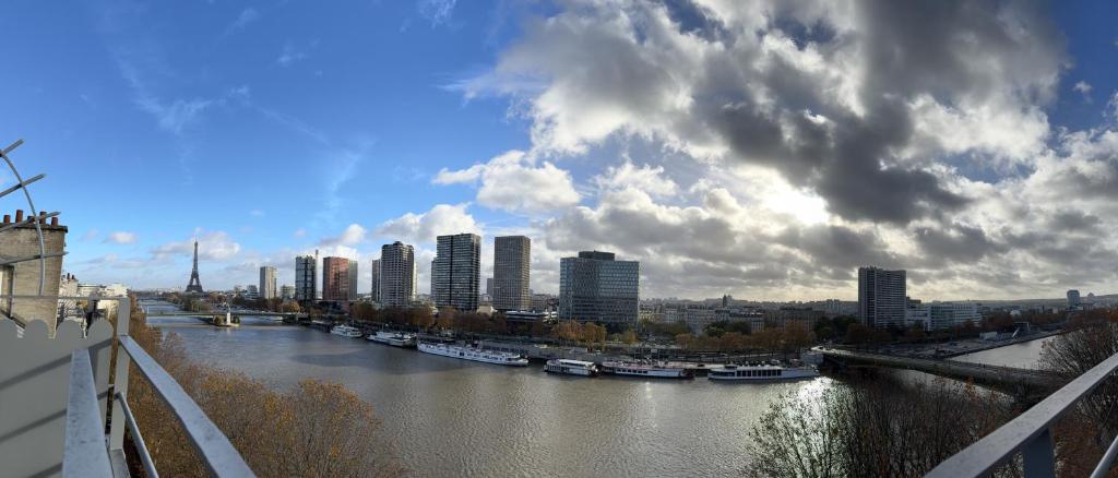 a view of a river with boats in a city at Appartement vue Tour Eiffel paris 16 Eme in Paris