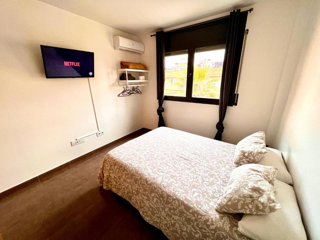 a small bedroom with a bed and a window at MT Nuevos Apartamentos y Suites con baño privado in Mataró