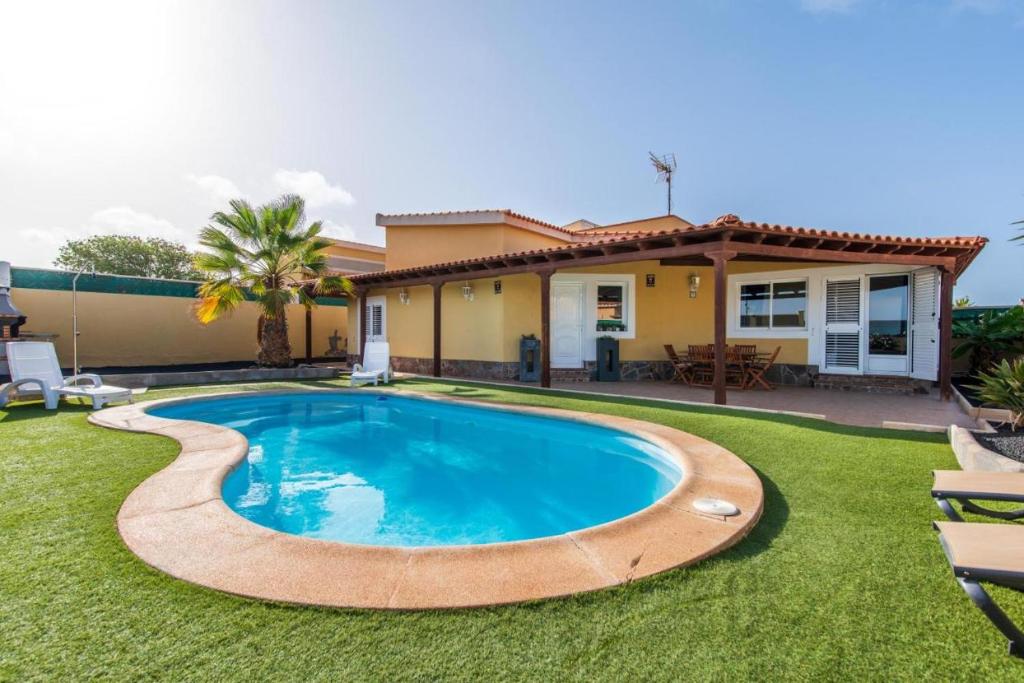 a swimming pool in the yard of a house at Villa Sophia in Caleta De Fuste