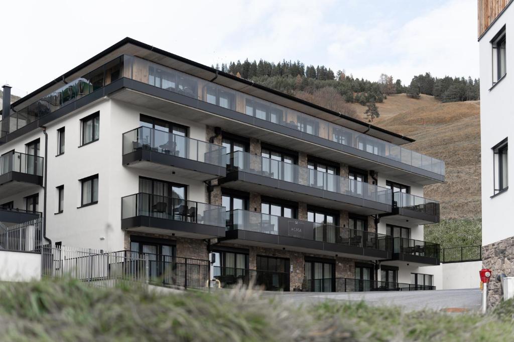 un edificio de apartamentos con balcones en una colina en A CASA Serenity, en Serfaus