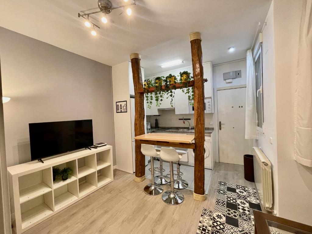 uma cozinha com um bar e uma televisão num quarto em Bonito apartamento junto a la Plaza Mayor em Madri