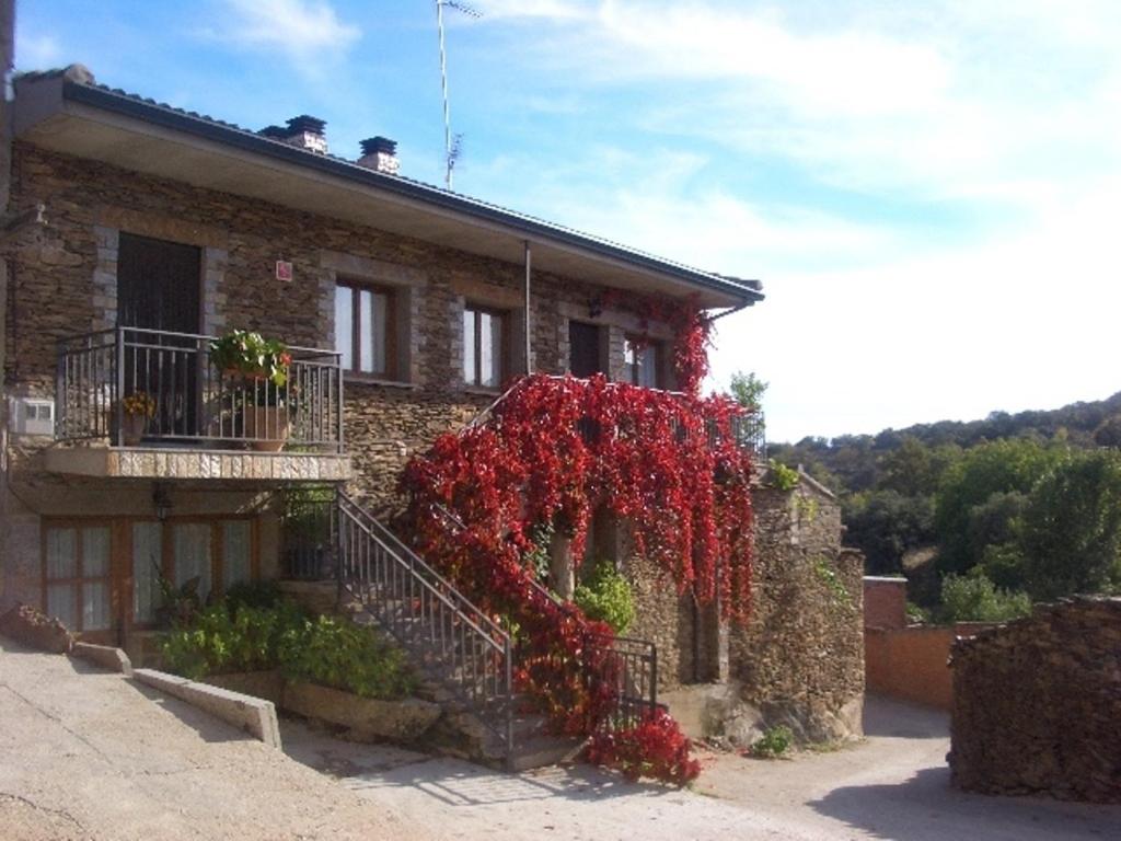 un edificio con flores rojas a un lado. en Apartamentos Albarcas, en Villares de Jadraque