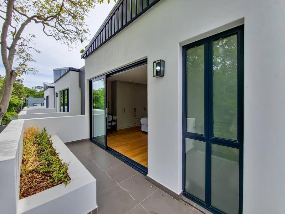 Biały dom z dużymi przesuwnymi szklanymi drzwiami w obiekcie Luxurious Family home in Newlands with Pool w Kapsztadzie